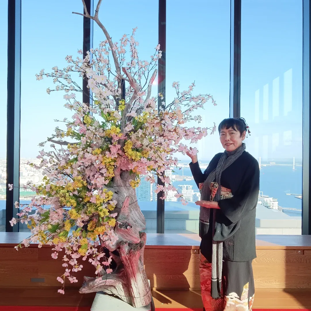 海を望む窓辺にいけられた桜と、かたわらに立つ横井紅炎
