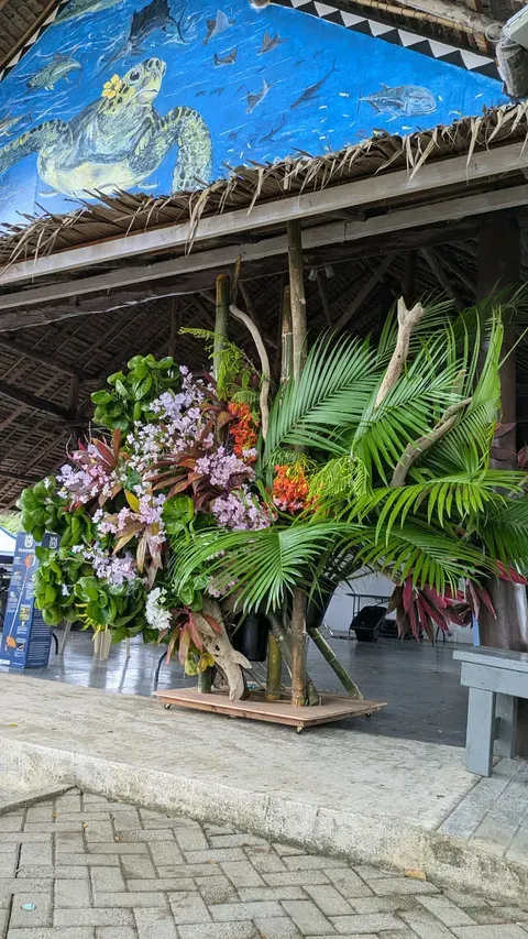 パラオの伝統家屋の下にいけられた南国花材の大型作品