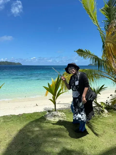 パラオの白い砂浜で、ヤシの若木のそばに立つ横井紅炎